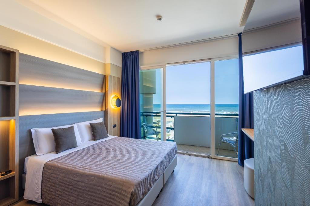 une chambre avec un lit et une vue sur l'océan dans l'établissement Hotel Palm Beach B&B SEA VIEW, à Rimini