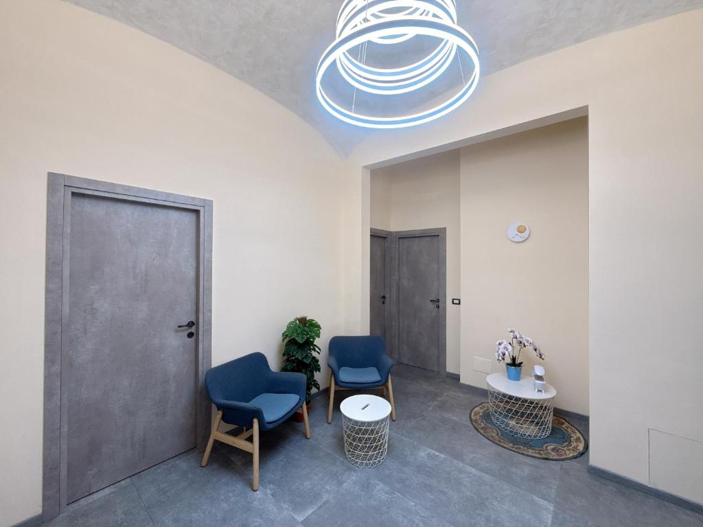 una sala d'attesa con due sedie blu e un tavolo di Hulin guesthouse a Roma