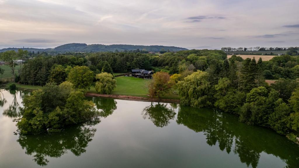 an aerial view of a house on a bridge over a lake at Nor67 - Witley Park House in Little Witley