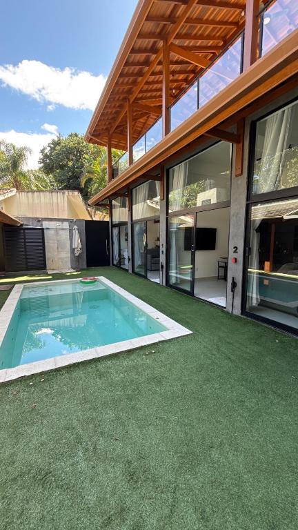 a house with a swimming pool in the yard at CasadevidroTTP Pé na areia in São Sebastião