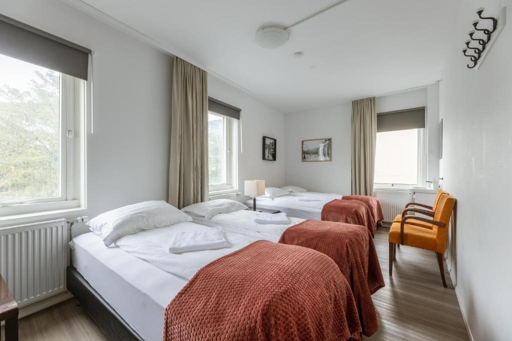 Una habitación de hotel con dos camas y dos sillas. en Old Town Reykjavik, en Reikiavik