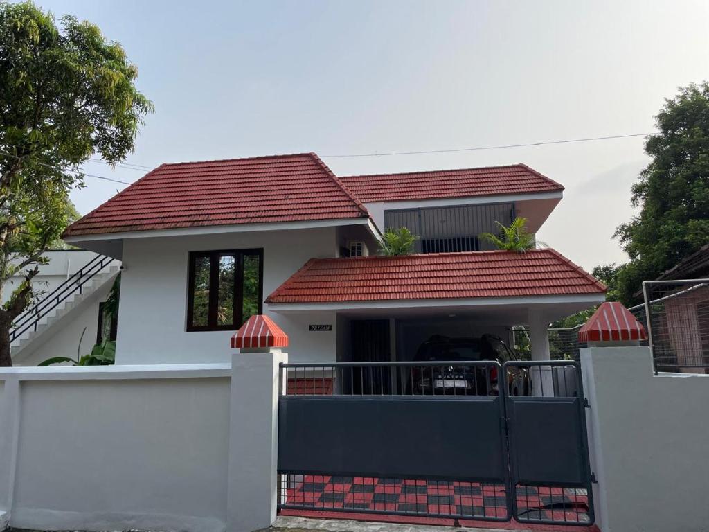 ChengannūrにあるTemple Courtyardの門と赤屋根の家