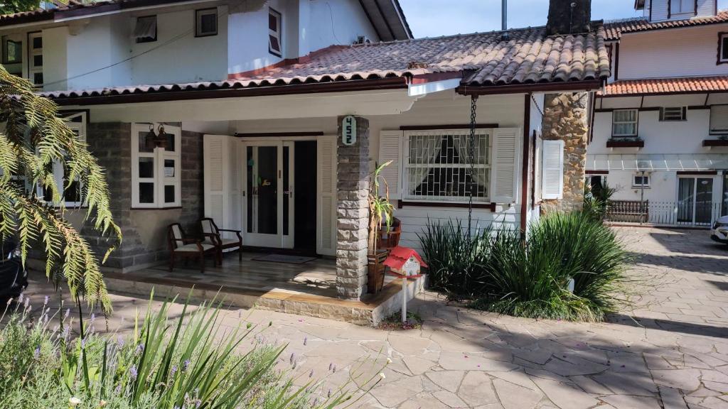 a small house with a porch with a fire hydrant at Recanto da Ladeira in Gramado