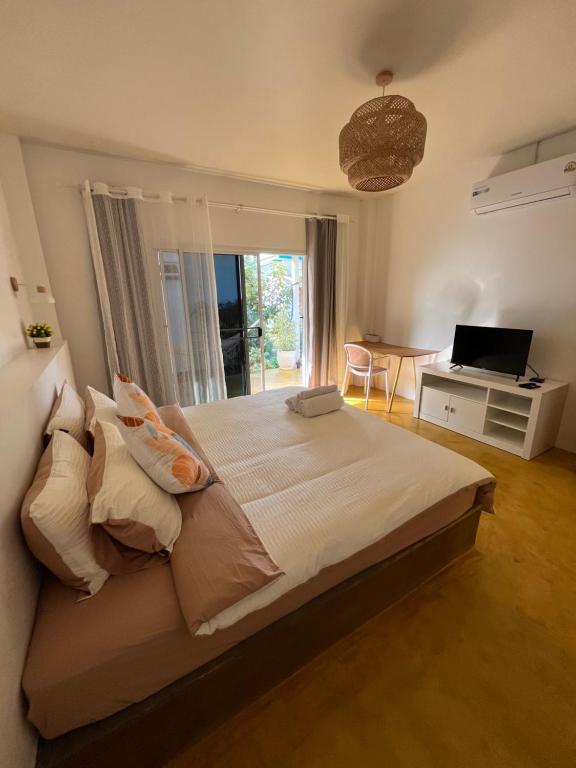 a bedroom with a bed and a desk with a laptop at The Summer Cottage in Khlaung Phai Bae