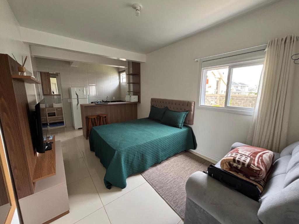 ein Wohnzimmer mit einem Bett und einer Couch in der Unterkunft Kitnet Suíte Premium in Bento Gonçalves