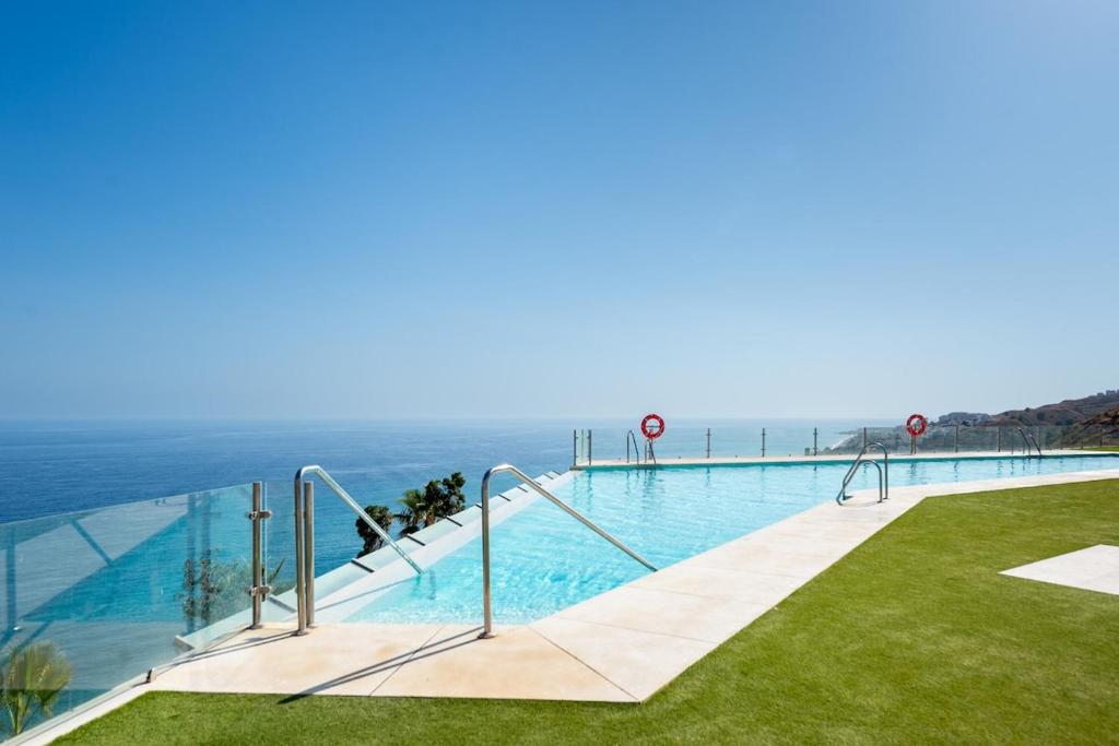 a swimming pool with the ocean in the background at Breathtaking Bay views Nerja in Torrox