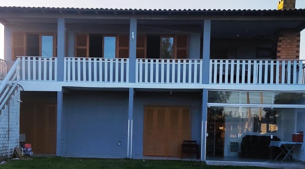 a house with a deck and a balcony at Casa Térrea de praia confortável para famílias in Tramandaí