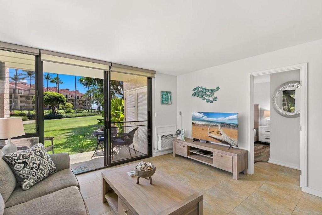 a living room with a couch and a tv at Kamaole Sands 1101 · KAS 1101 Updated Beachy Chic 2BD Across Bea in Wailea