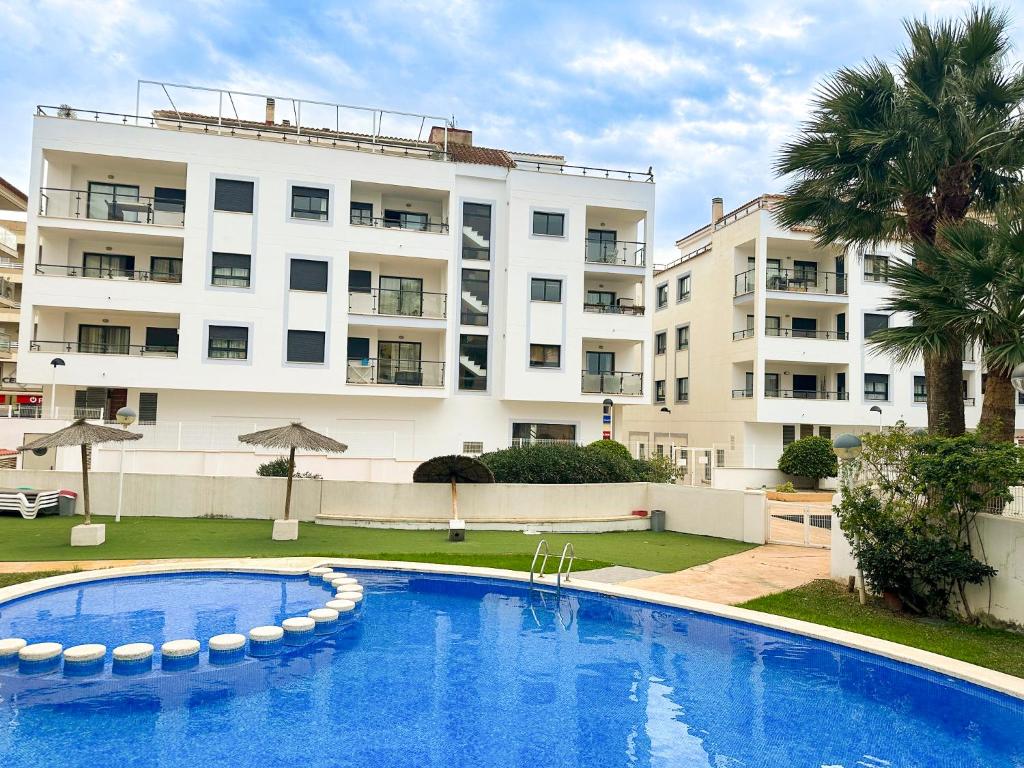 a swimming pool in front of a large apartment building at Calamora-Moraira in Moraira