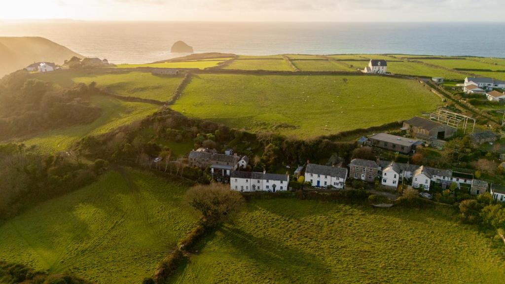 eine Luftansicht eines Hauses auf einem Hügel neben dem Meer in der Unterkunft 1 Rock Cottages in Treknow