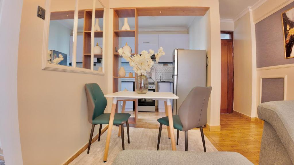 a kitchen and dining room with a table and chairs at Modern 3BR Apt with Pool within UN-Approved Zone, Kiambu Rd in Nairobi