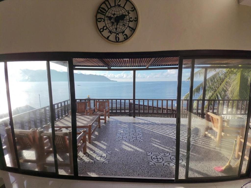 GuindulmanにあるDENTRISTOD Vacation Rentalの海が見えるバルコニーの上の壁に掛けられた時計