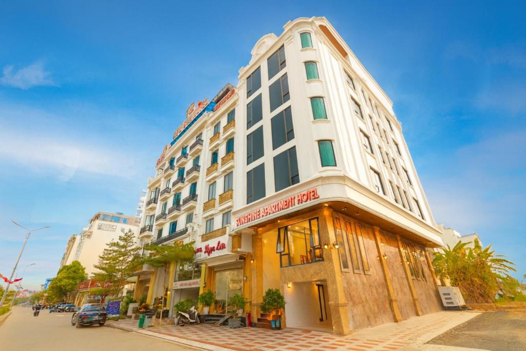 a tall white building on a city street at Sunshine Apartment Hotel in Móng Cái