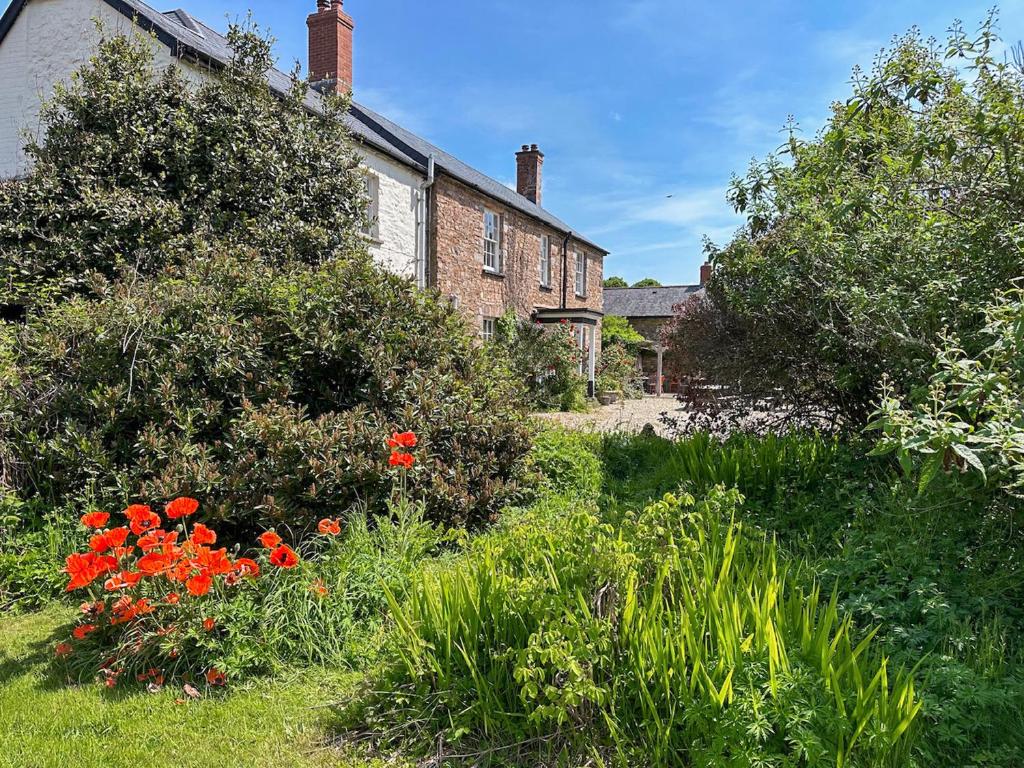 een oud bakstenen huis met een tuin ervoor bij Duvale Priory - 9985 in Bampton