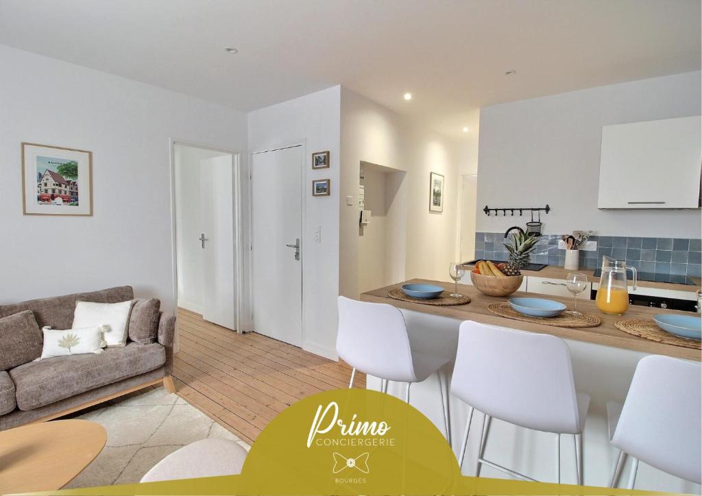 a kitchen and living room with a table and chairs at Le Logis Saint-Ursin by PRIMO C0NCIERGERIE in Bourges