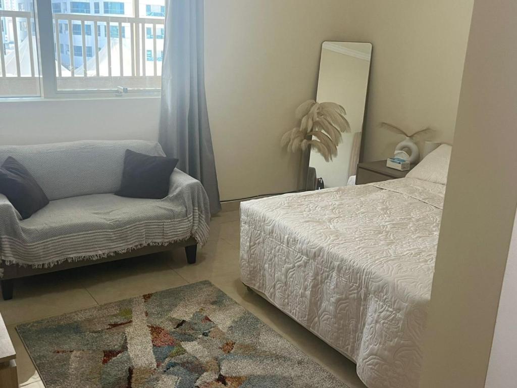 a bedroom with a bed and a chair and a mirror at comfort private master room in Sharjah