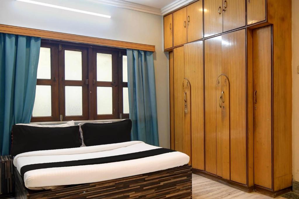 ein Schlafzimmer mit einem Bett und einem großen Fenster in der Unterkunft Hotel O Avenue Villa in Dum Dum