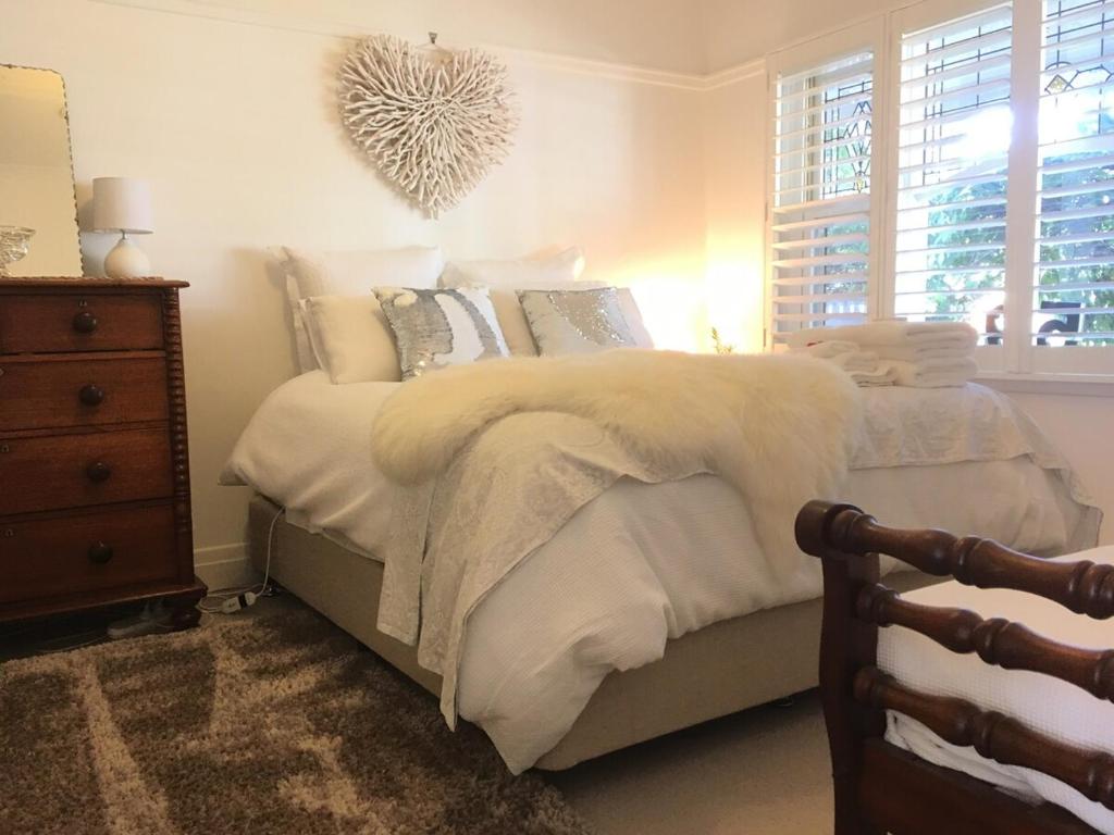 ein Schlafzimmer mit einem Bett mit einer Decke und einer Kommode in der Unterkunft Newport Cottage sleeps 5 in Newport