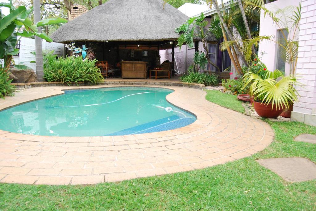 a small swimming pool in a yard with a gazebo at Ronique's Guest House in Rustenburg