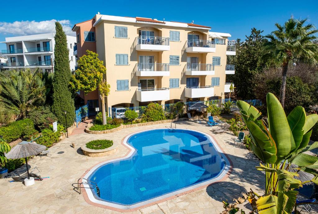 een appartement met een zwembad voor een gebouw bij Hermes Gardens in Paphos City