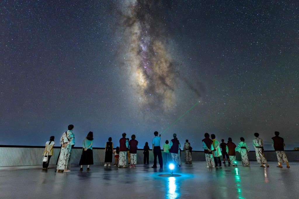 a group of people standing on a roof looking at the universe at Ashizuri Kokusai Hotel in Tosashimizu