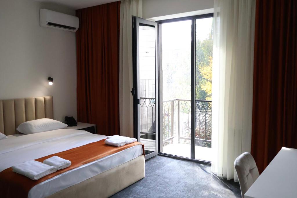 a hotel room with a bed and a sliding glass door at New Casa Boutique Hotel in Yerevan