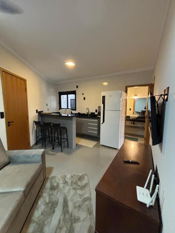 a living room and kitchen with a couch and a table at Alabama in Ribeirão Preto