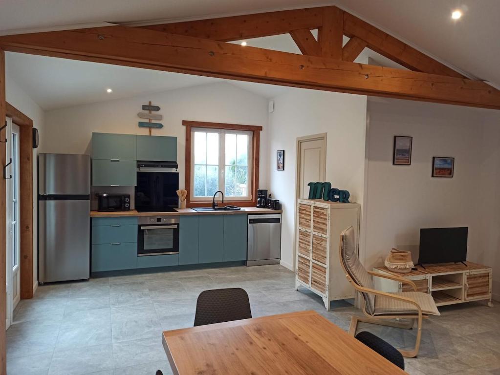 eine Küche mit blauen Schränken und einem Holztisch in der Unterkunft Maison de vacances Ile d'Oléron 2 Chambres in Saint-Pierre-dʼOléron