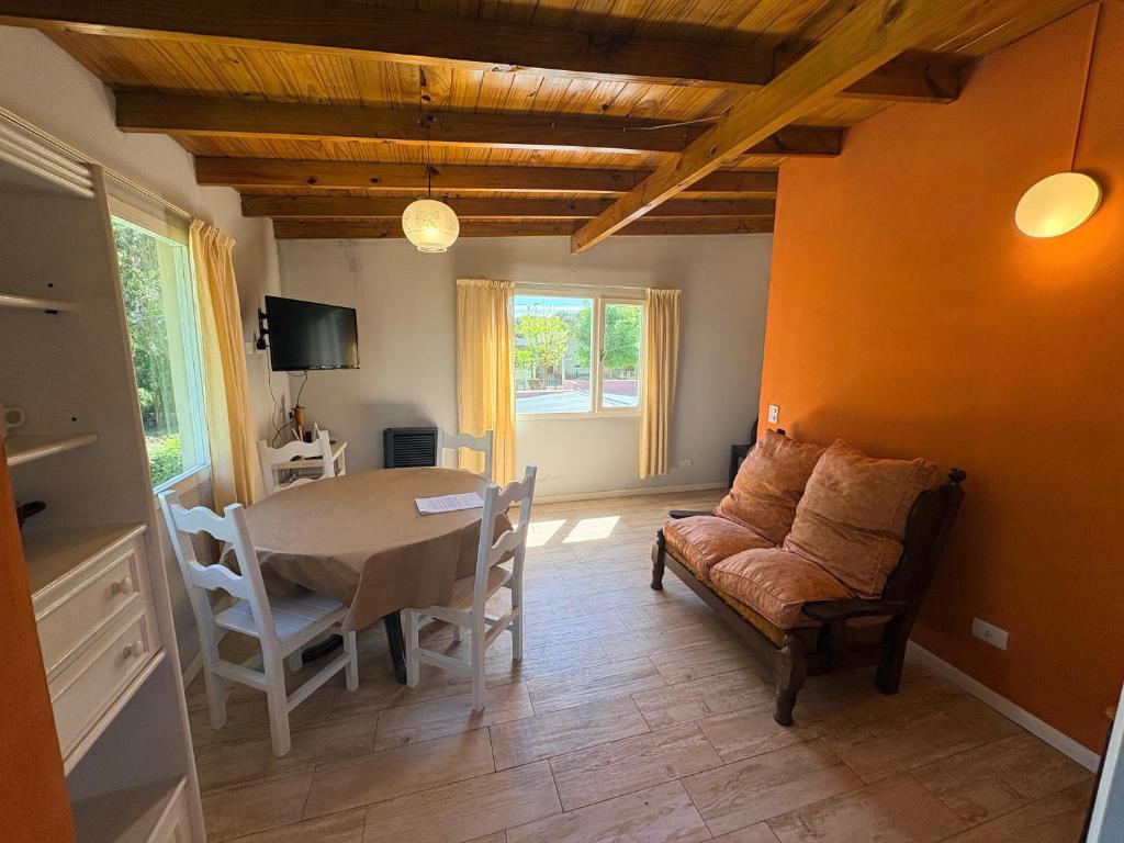 a living room with a table and a couch and a chair at Dpto amplio en la naturaleza cerca del mar y del centro de Pinamar in Ostende