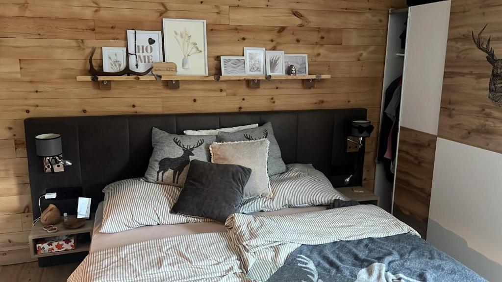 a bedroom with a bed with a wooden wall at Farmhouse- Bed and Breakfast Kösslergut in Zederhaus