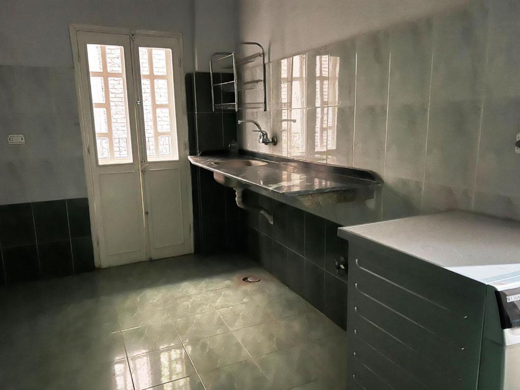 a kitchen with a counter and a sink and a door at Kareem Hotel Luxor in Luxor