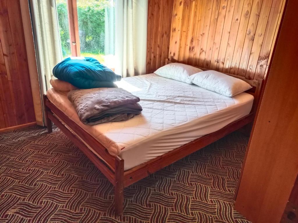 uma cama com dois travesseiros em um quarto em Cabaña familiar para 6 pax en pucon em Pucón