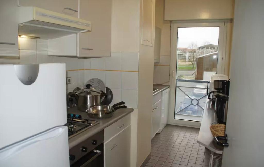 a kitchen with a white refrigerator and a window at Casa Baïla in Rochefort