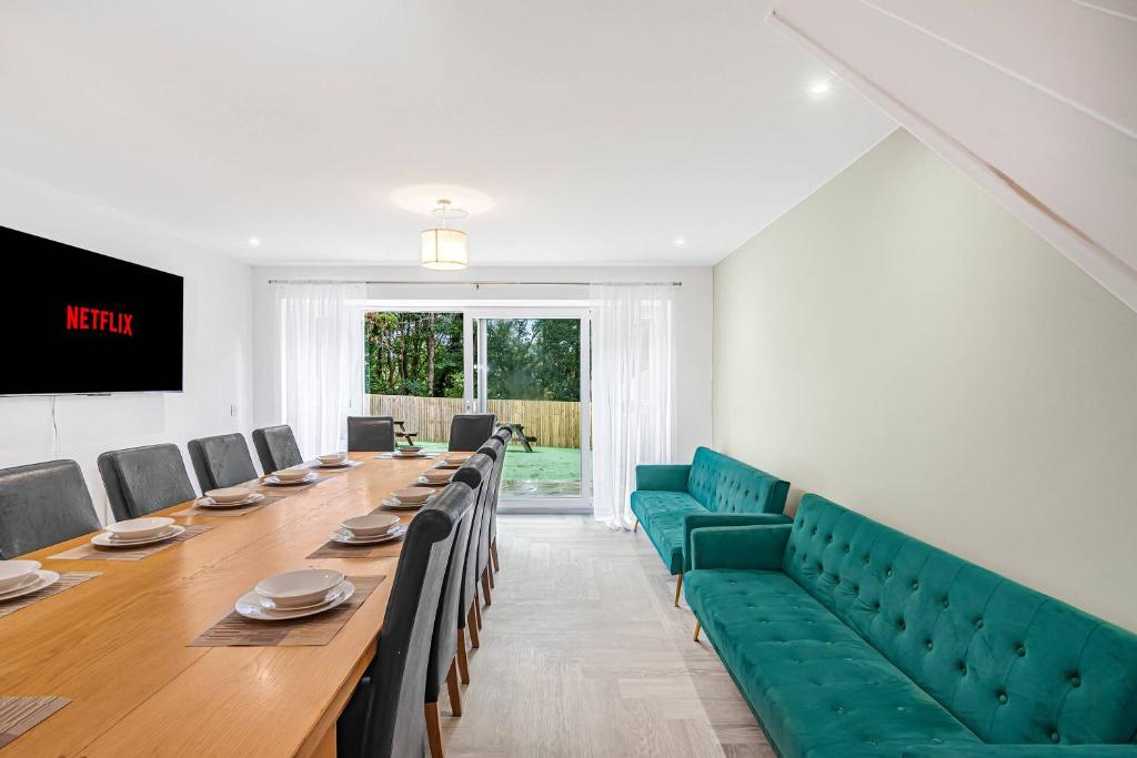 a conference room with a long table and green chairs at The Roost Group - 5 Bed House Hot Tub Near Beach in St. Leonards