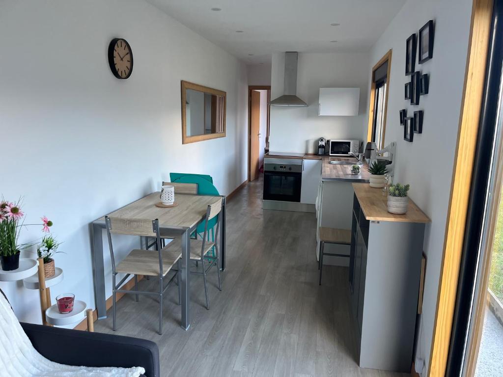 a kitchen and living room with a table and chairs at Casinha do codecal in Labruja