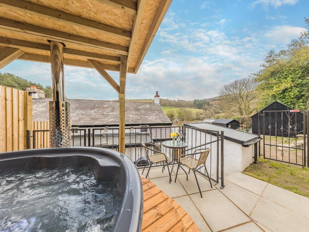 a hot tub on the deck of a house at The Cottage At Number One in Caerwys