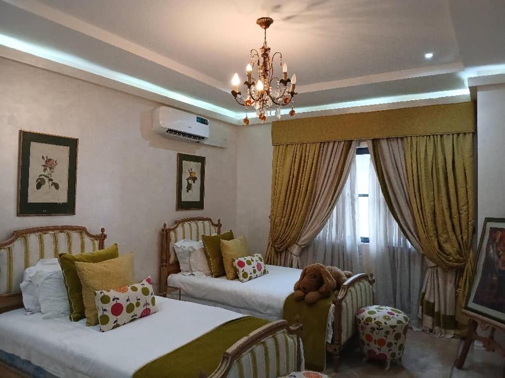 a bedroom with two beds and a chandelier at Vaj in Lagos