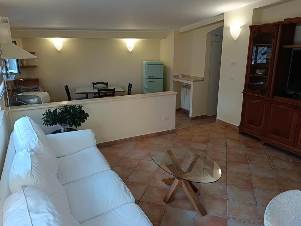 a living room with a white couch and a table at Casa Mille Lire in Ciampino