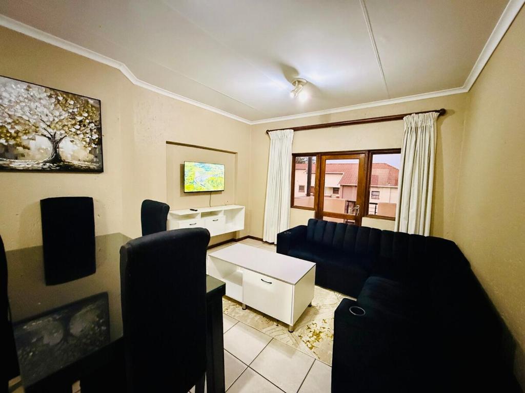 ein Wohnzimmer mit Sofa und Tisch in der Unterkunft Sandton Skyline Suite - 2 Bedroom Apartment in Sandton