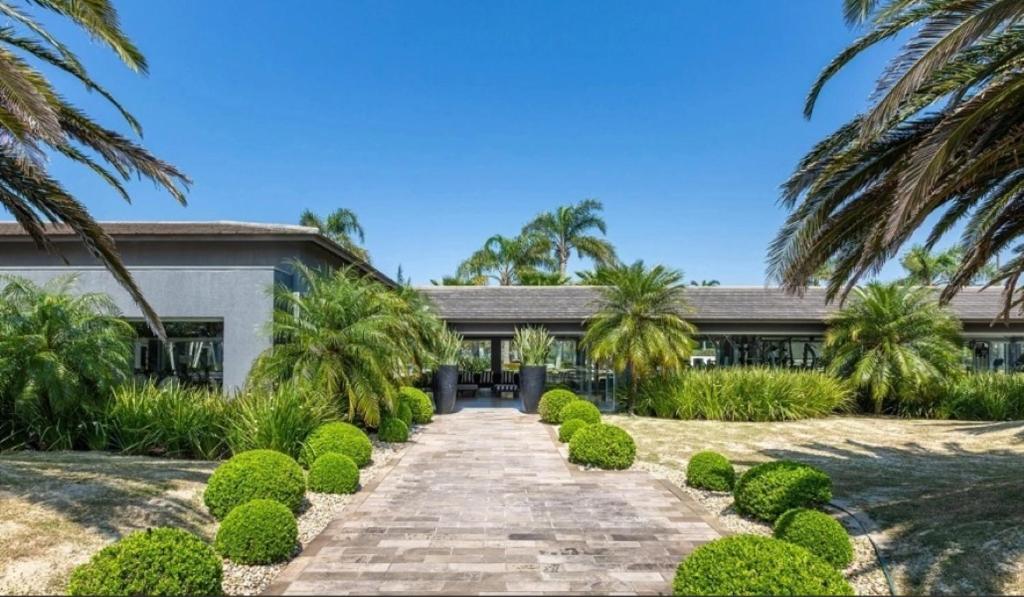 an exterior view of a house with palm trees at Condomínio Ilhas Park Xangri-lá in Xangri-lá
