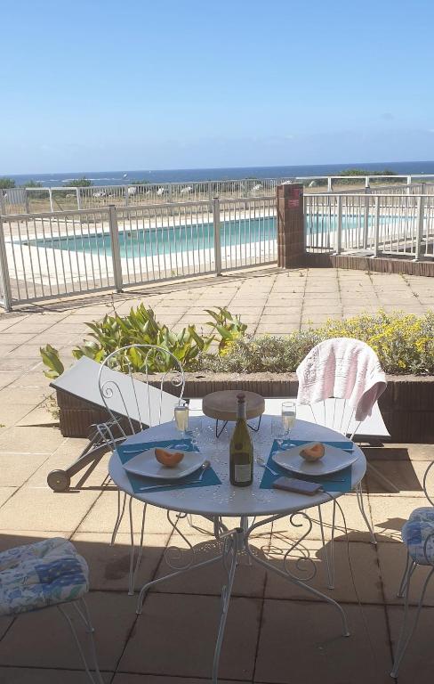 a table and chairs on a patio with the beach at Maeva 7 in Guidel