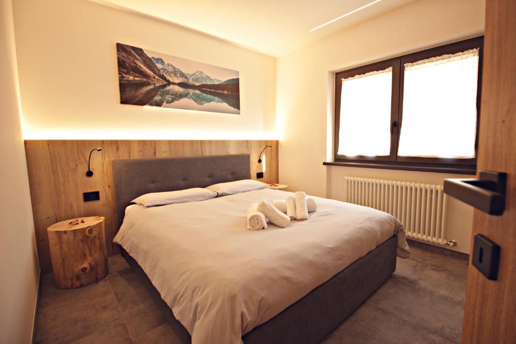 a bedroom with a bed with two towels on it at Guest House Cemin in Predazzo