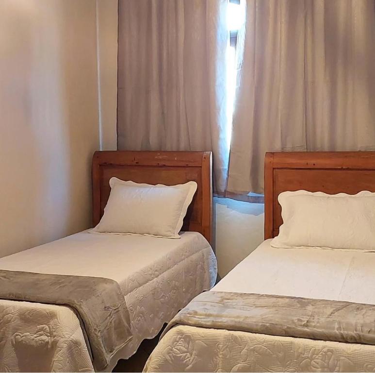 duas camas lado a lado em um quarto em Hospedagem cama e café em Domingos Martins