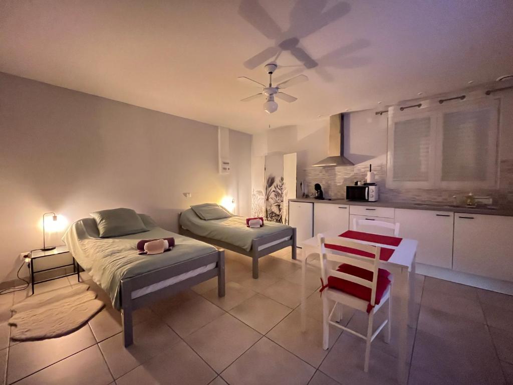 una camera da letto con un letto, un tavolo e una cucina di Joli Studio proche CNPE du Blayais a Saint-Aubin-de-Blaye