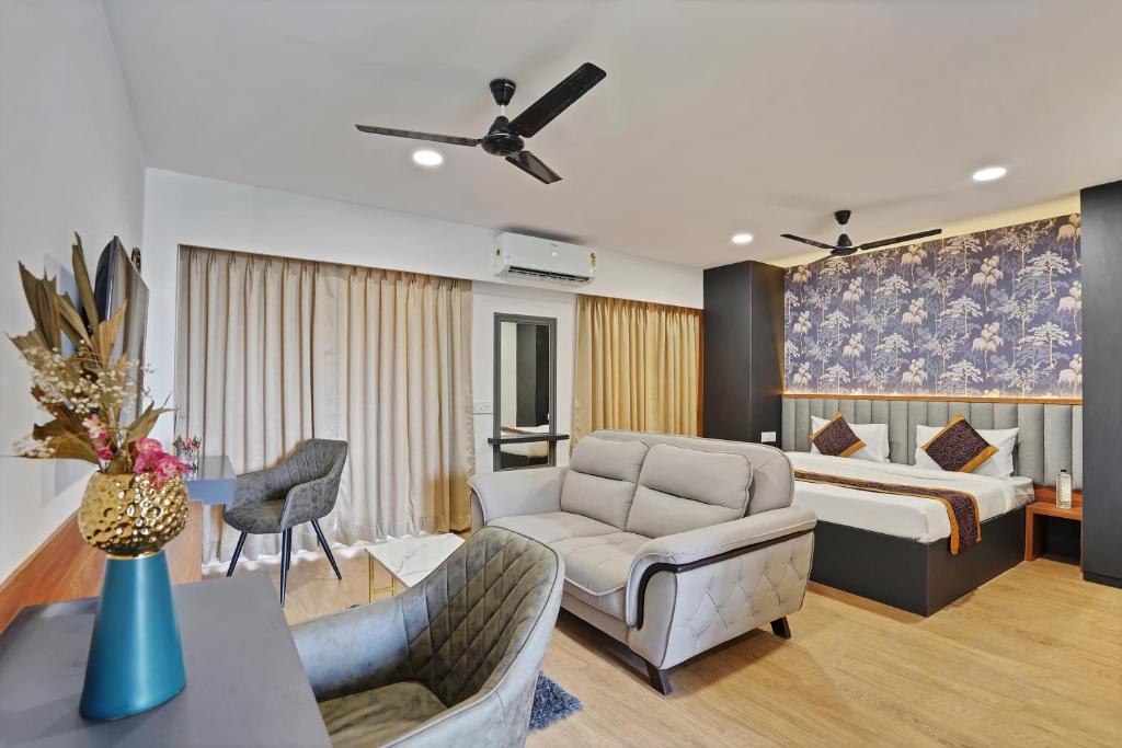 a bedroom with a bed and a living room at Charvi Suites in Pune