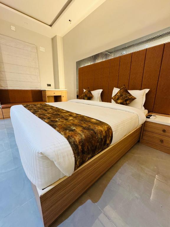 a bedroom with a large bed with a wooden headboard at Hotel RS Grand in Kashi