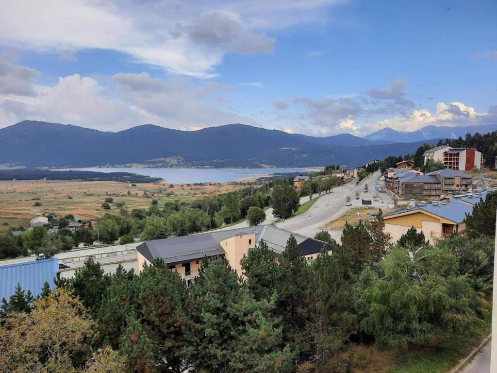 a view of a town with a lake and mountains at Nid des Angles - Cœur de station vue Lac & Montagne in Les Angles
