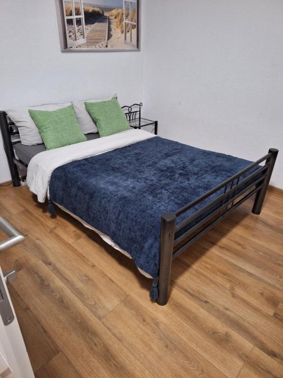 a bed with green pillows on it in a room at Suma Appartment 10min from Railstation in Koblenz