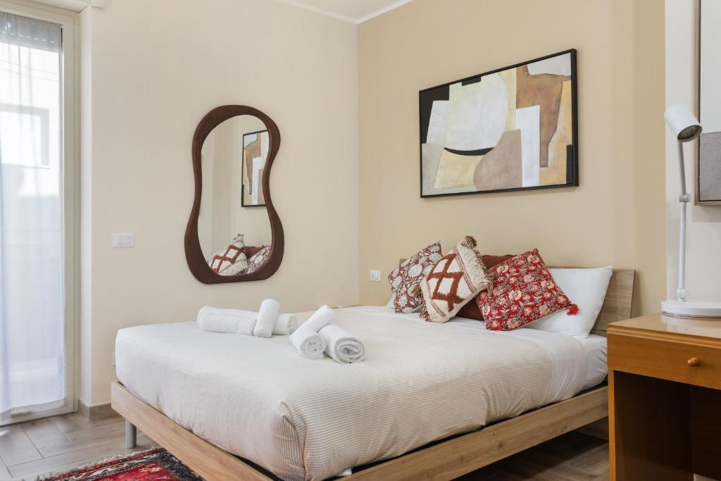 a bedroom with a white bed with pillows and a mirror at Conca D'Oro Guest House - Stefania in Rome