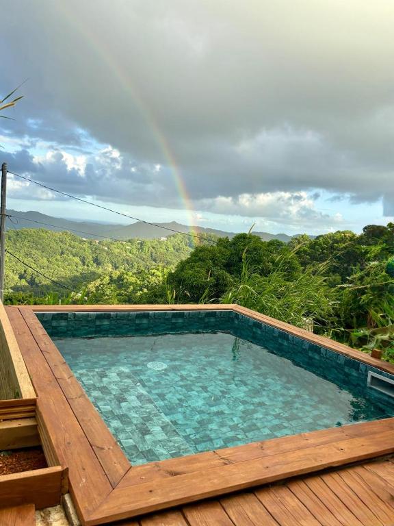 a swimming pool with a rainbow in the background at Chill lodge in Sainte-Luce